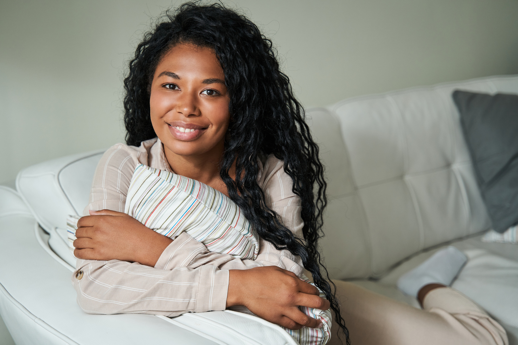 Black woman sitting on couch and looking at camera